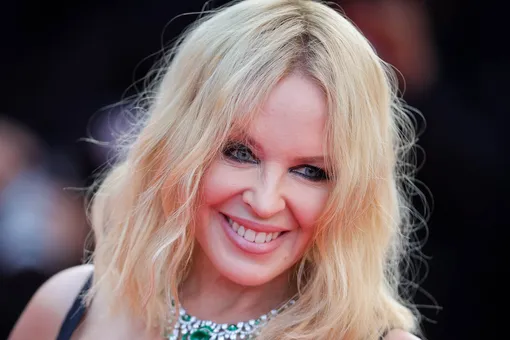 Кайли Миноуг в белом латексном платье с открытыми плечами появилась на публике Кайли Миноуг в белом латексном платье с открытыми плечами появилась на публике