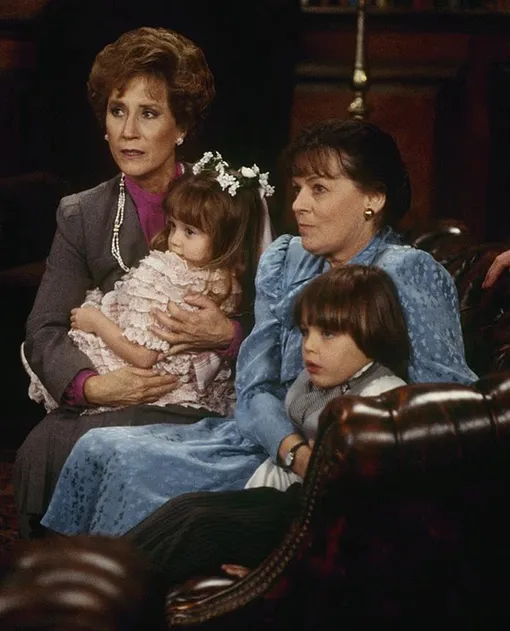 Бетти Харфорд (в синем платье) в сериале «Династия»