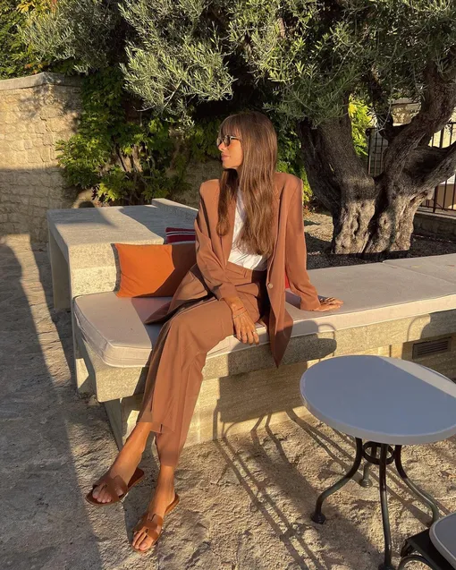 В теплое время года дополняй расслабленный брючный костюм кожаными шлепанцами.