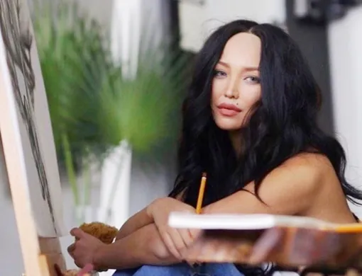 Молодая художница пишет картины в стиле ню